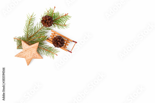Christmas background of fir twigs  wooden zero waste home decoration  sleigh  cone  and star