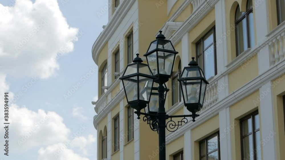 Street lamp against the hotel facade and cloudy daytime sky Street lamp against the hotel facade and cloudy daytime sky