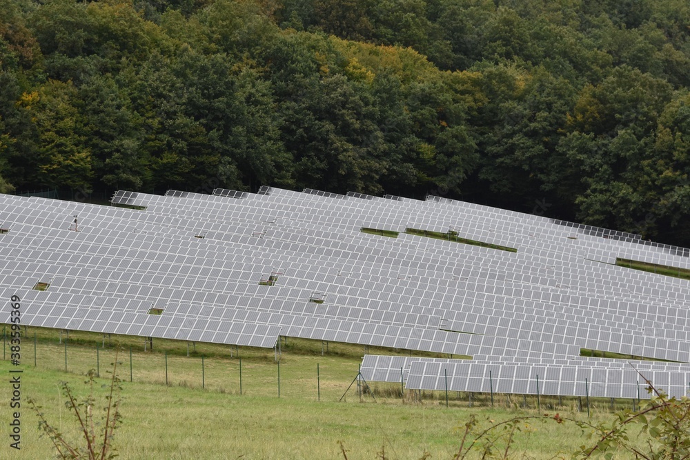 Solar panels placed on a meadow in dense rows, in Zarnovica, district town in Slovakia, Europe. An example of use of renewable resources for production or generation of electricity. Solar panels placed on a meadow in dense rows, in Zarnovica, district town in Slovakia, Europe. An example of use of renewable resources for production or generation of electricity.