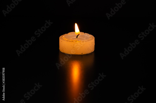 Single Candle burning at night.