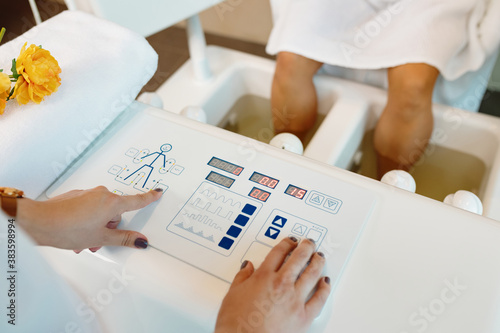 Close-up of a therapist adjusting device screen during hydrotherapy at the spa.
