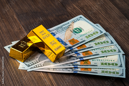 gold bar on dollar bills