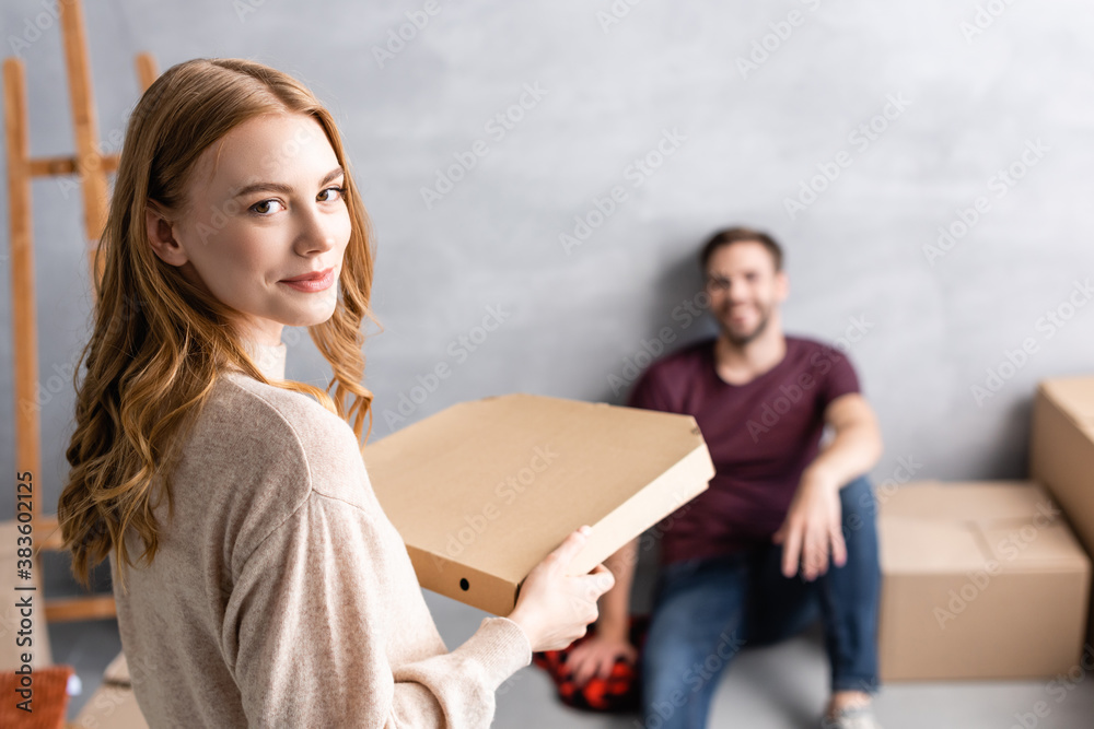 selective focus of young woman holding carton pizza box near boyfriend selective focus of young woman holding carton pizza box near boyfriend