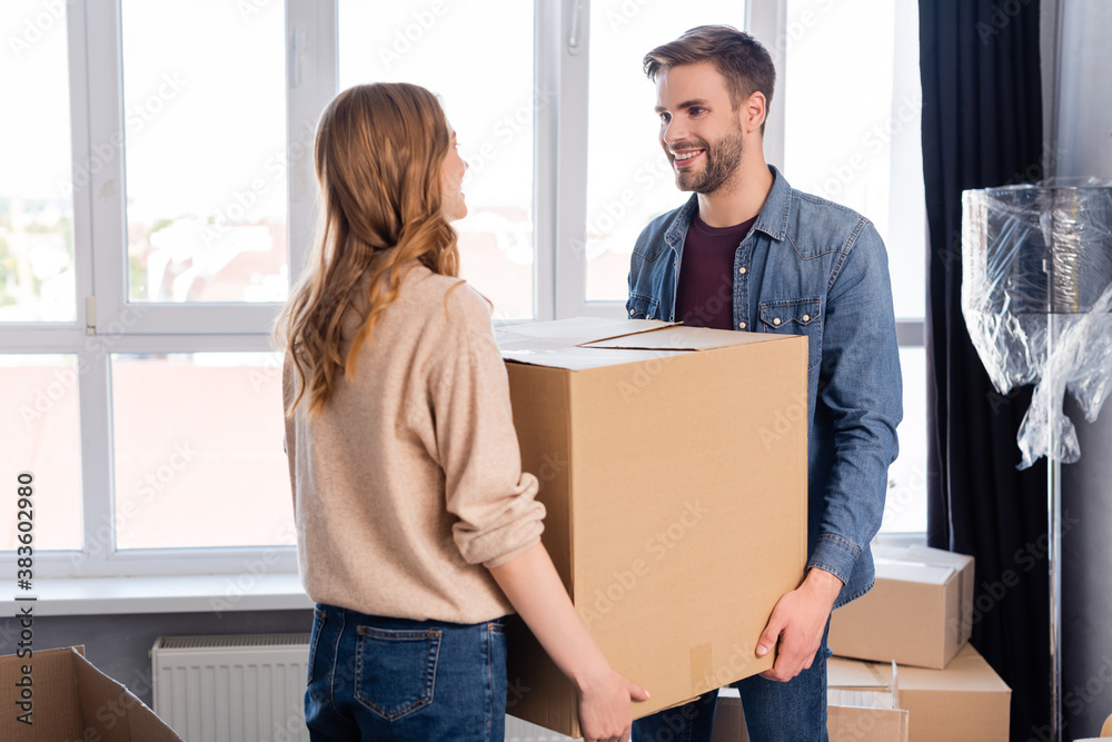 bearded man and woman holding carton box, moving concept bearded man and woman holding carton box, moving concept