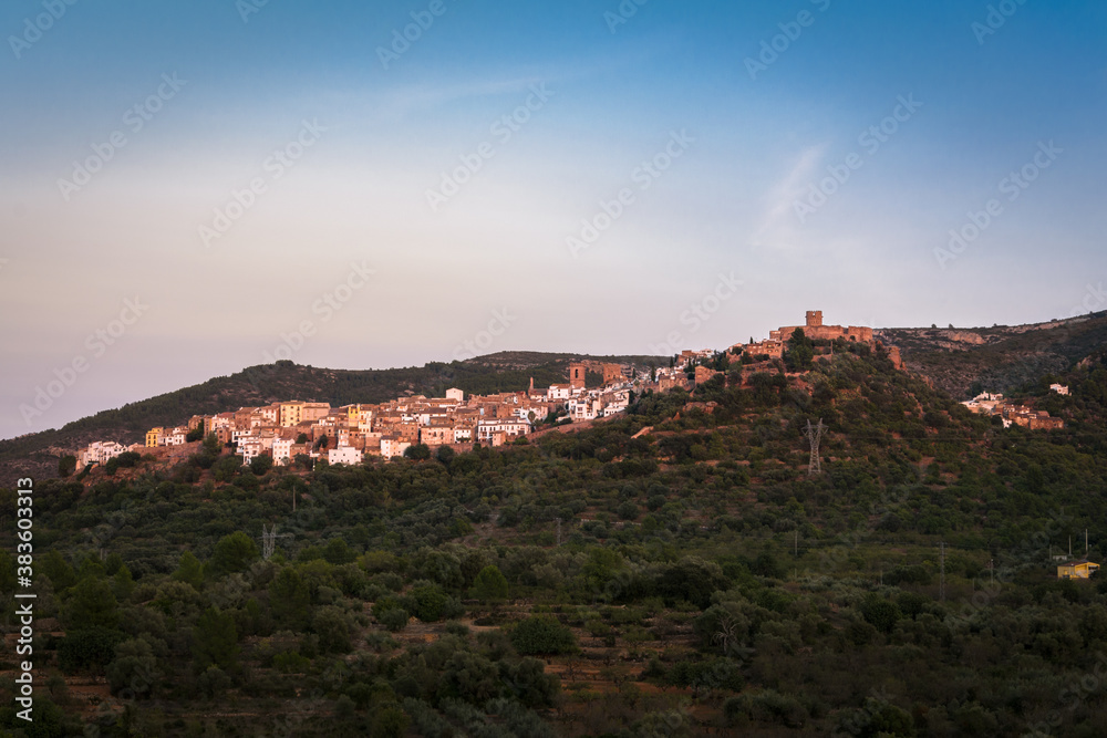 Landscape of the historic town of Villafames surrounded by trees at sunset with the castle on the top of the hill, Castellon, Spain