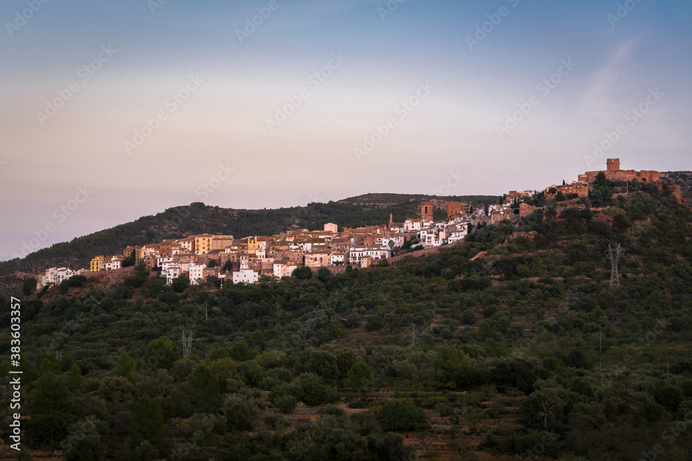 Landscape of the historic town of Villafames surrounded by trees at sunset with the castle on the top of the hill, Castellon, Spain