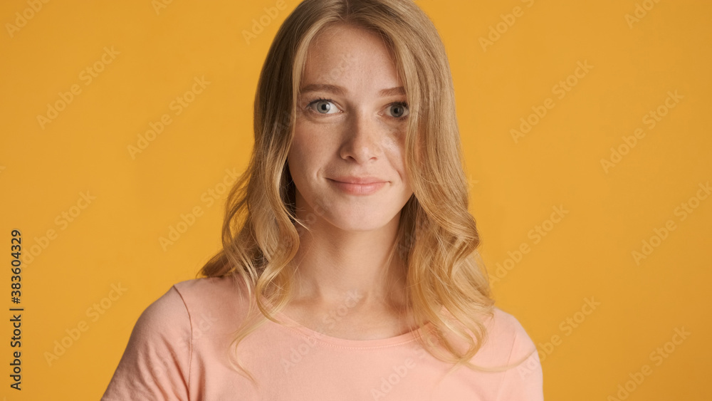 Portrait of attractive girl posing on camera over yellow backgro Portrait of attractive girl posing on camera over yellow backgro