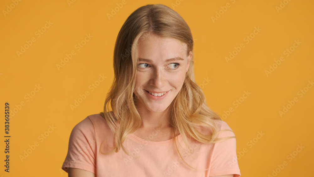 Beautiful charming girl dreamily posing on camera isolated on ye Beautiful charming girl dreamily posing on camera isolated on ye
