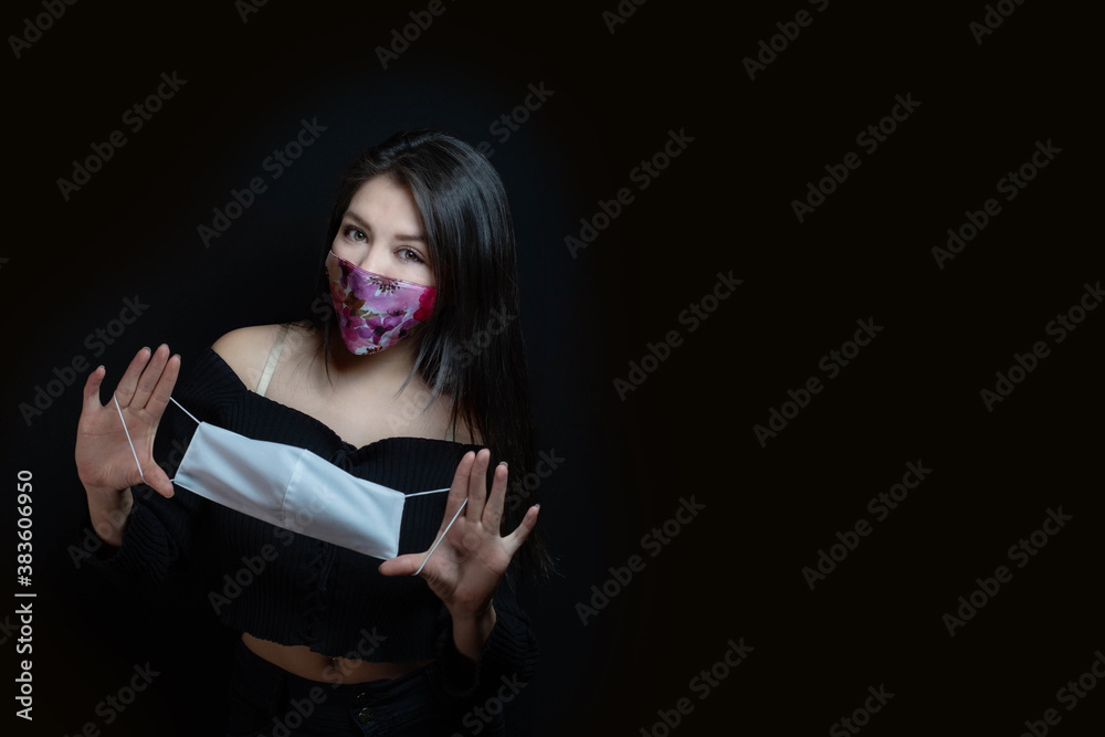 Woman with mask, showing white mask with black background Woman with mask, showing white mask with black background