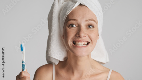 Portrait of girl with towel on head and toothbrush in hand smili photo