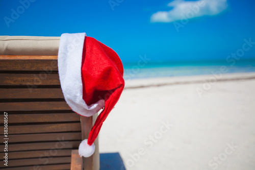 Fototapeta Naklejka Na Ścianę i Meble -  Close-up of santa hat on chair longue at tropical caribbean beach