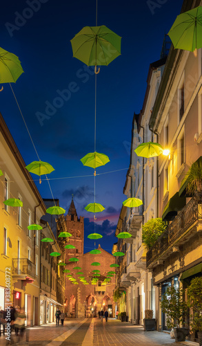 Hanged green umbrellas along the main street of Monza during dusk  Lombardy  Italy