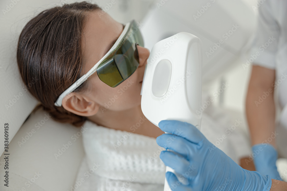 Naklejka premium Beautiful healthy smiling caucasian woman is doing beauty procedures at spa and healthcare salon