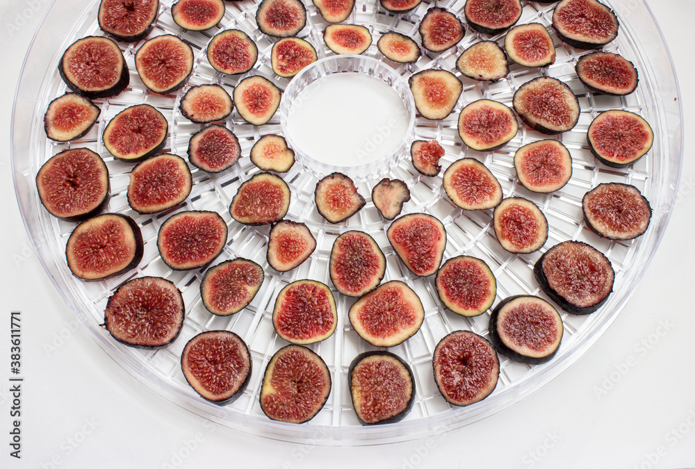 Fig. Purple berries with red flesh are cut into round slices. Laid out on a grid dehydrator. The preparation of wholesome snacks. Dried fruits.