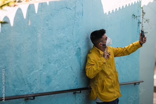 Chico con abrigo amarillo en calles azules de Júzcar en Andalucía photo