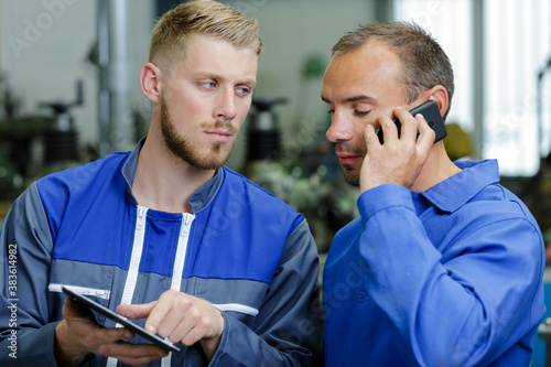 mechanic showing data to supervisor of garage