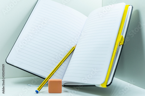 A nice notebook or diary together with a pen and an eraser, isolated with a white background