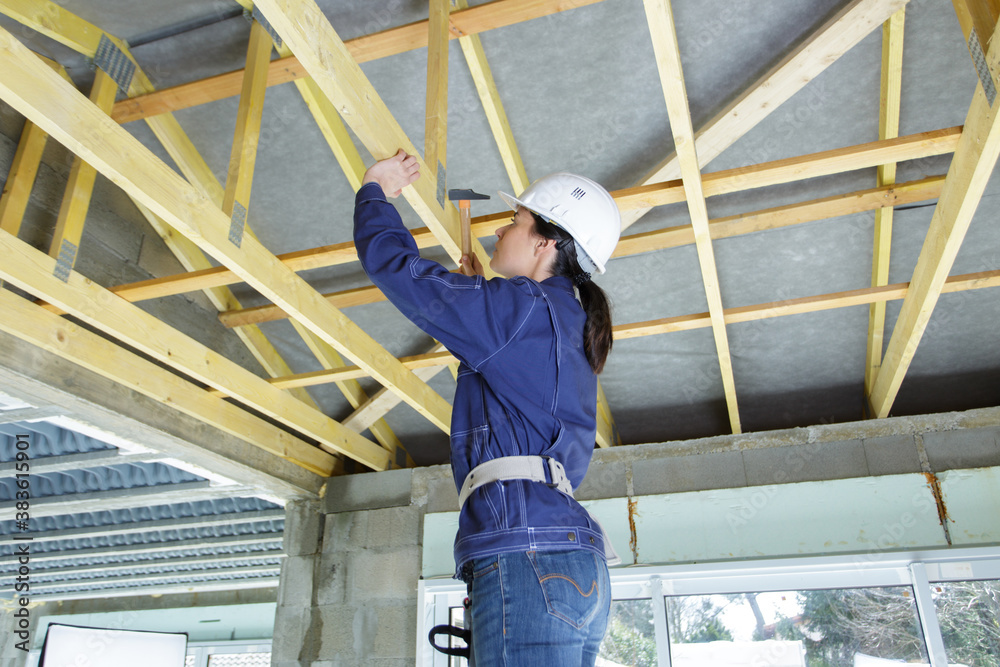 female carpenter working on a wood structure female carpenter working on a wood structure