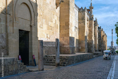 Lareral of the Mosque of Cordoba with the statue of San Rafael at the end of the street photo