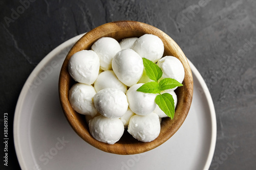 Mini mozzarella balls with basil in wooden plate