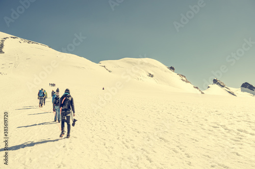 Rope team crossing glacial plateu before ascending a peak.