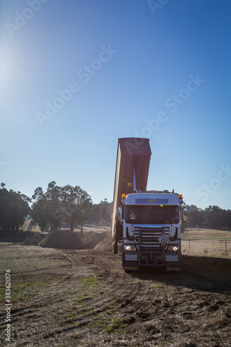 Tip truck tipping off lime in a paddock photo