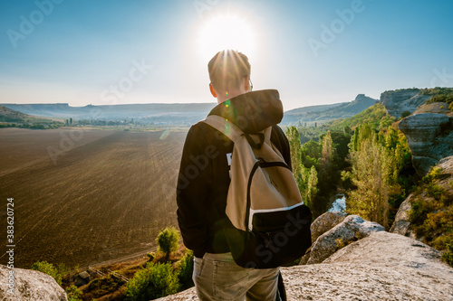 Φωτογραφία Young man in jacket standing admiring a mountaintop view looking out over distan