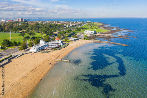 Aerial view of a bay side beach with surrounding parkland and sporting reserves photo
