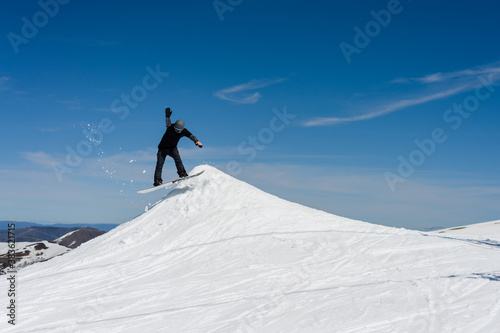 snowboarding practicing jumps in a terrain park