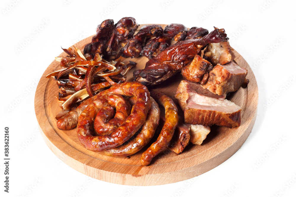 .Appetizing smoked meat, fried sausages, ribs on a wooden tray. Nicely and neatly served. cutout .Appetizing smoked meat, fried sausages, ribs on a wooden tray. Nicely and neatly served. cutout
