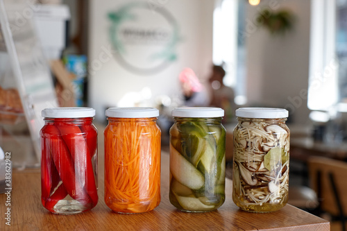 Variety of pickle jars lined up on counter in cafe photo