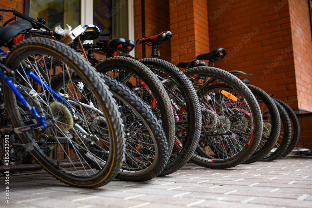 bicycles in a parking lot near a red brick wall