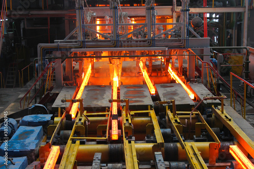 Red hot steel metal billets after molten steel casting.  Continuous casting machine. Background of the blacksmith and metallurgical industry.
