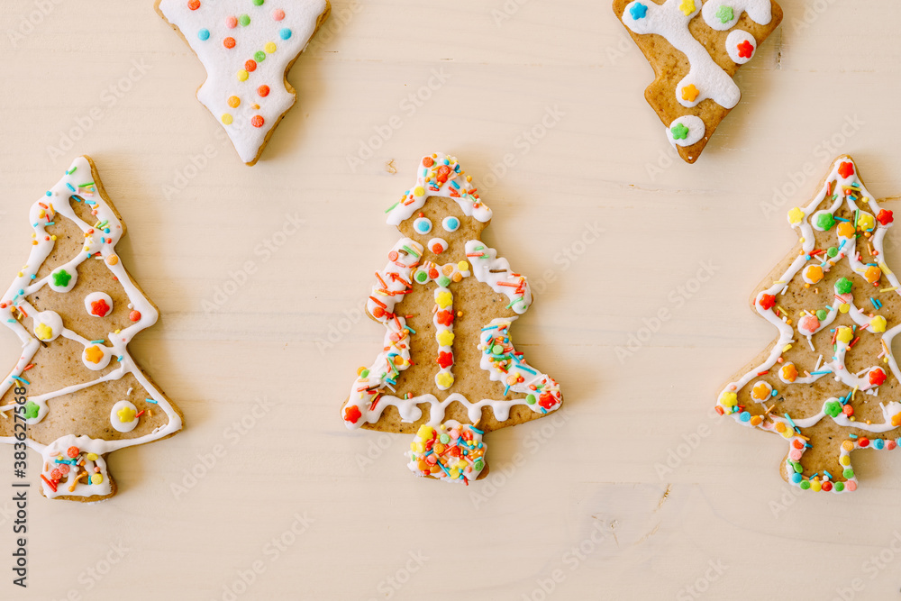 Five differently decorated gingerbreads in the shape of a Christmas tree, on a white background.
