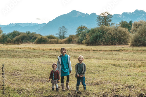 Kinder stehen auf dem Feld vor den Bergen