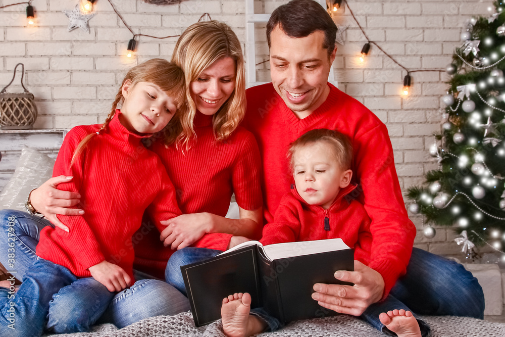 happy family reading a book at home at christmas happy family reading a book at home at christmas