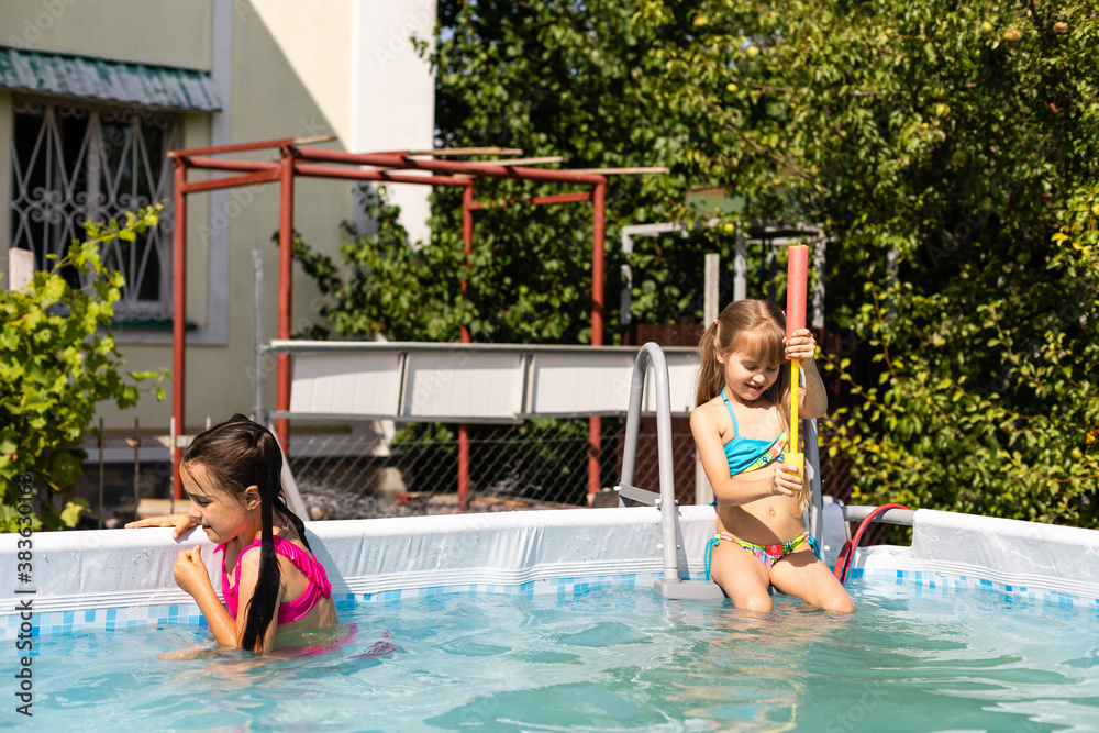 Kids in swimming pool. Girl swim outdoors.
