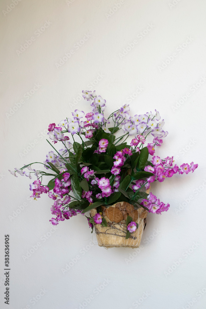 Artificial flowers on a light background. Flower basket