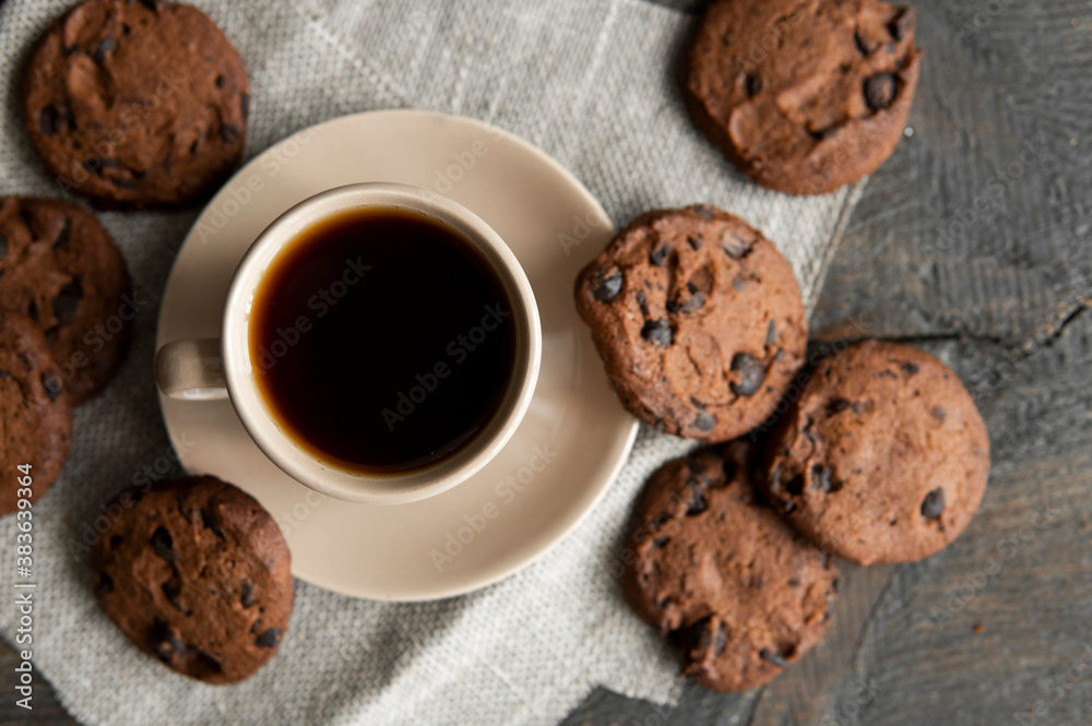 Coffee cup with cookies on wooden table background. Mug of black coffee with chocolate cookies. Fresh coffee beans. Coffee cup with cookies on wooden table background. Mug of black coffee with chocolate cookies. Fresh coffee beans.