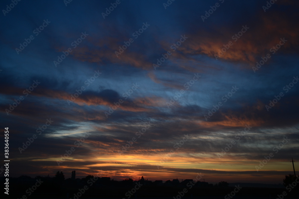 sunset over the village with tree silhouettes