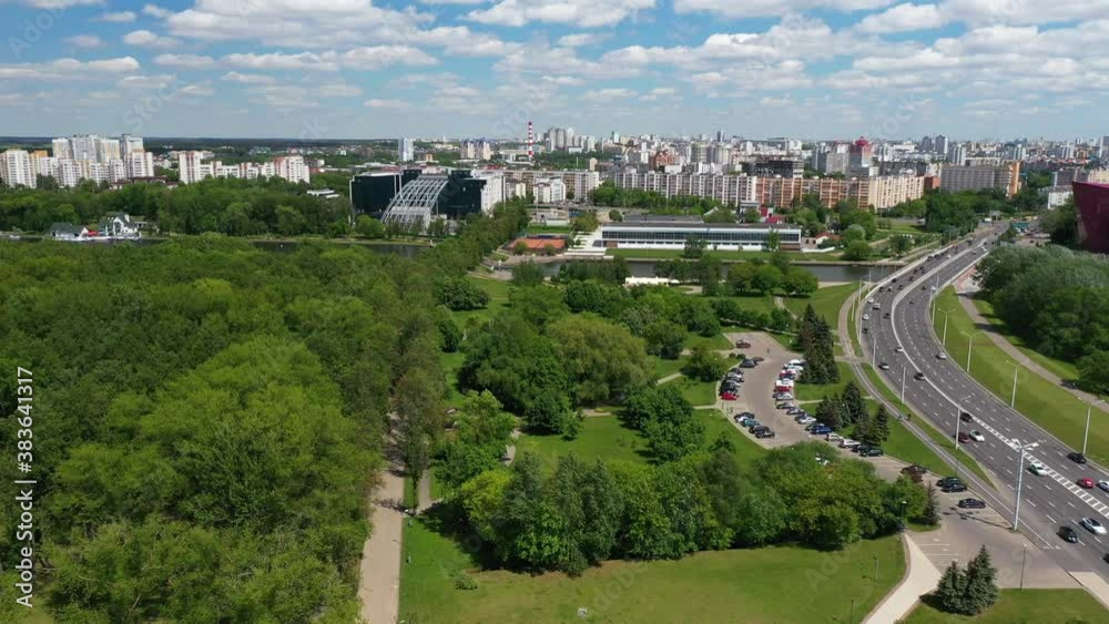 View of Masherov Avenue in Minsk, Belarus. Cars move fast along the highway in the city. Top view from drone. Top view of the city landscape. Buildings and roads in summer.
