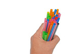 Close up a man hand is holding colourful straws over the white background.