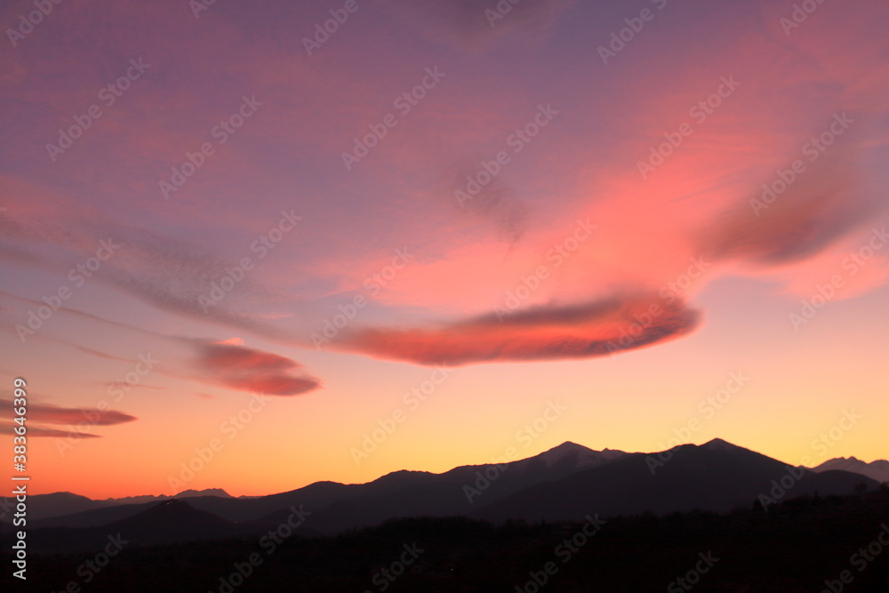 a romantic sunset with pink clouds over the Italian Alps