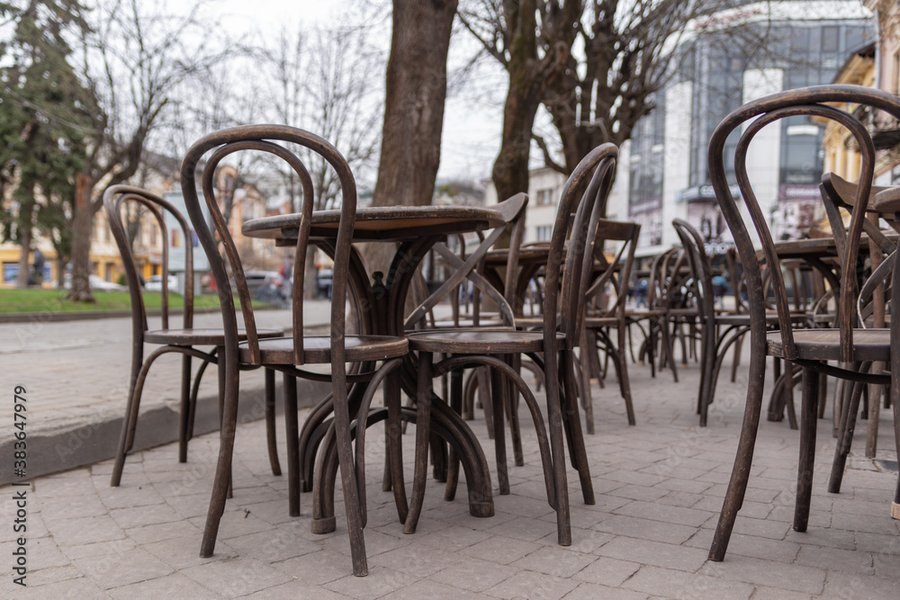 wooden tables with chairs of a street cafe without visitors, time of pandemic, quarantine, restrictions wooden tables with chairs of a street cafe without visitors, time of pandemic, quarantine, restrictions