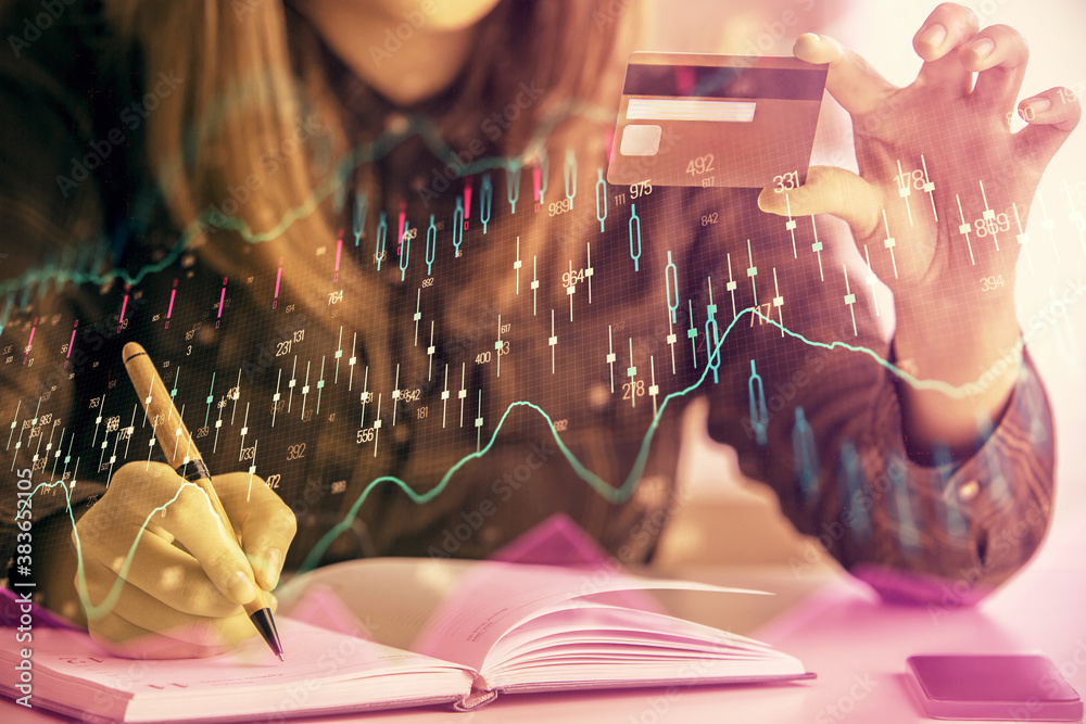 Multi exposure of woman on-line shopping holding a credit card and financial graph drawing. Stock market E-commerce concept.