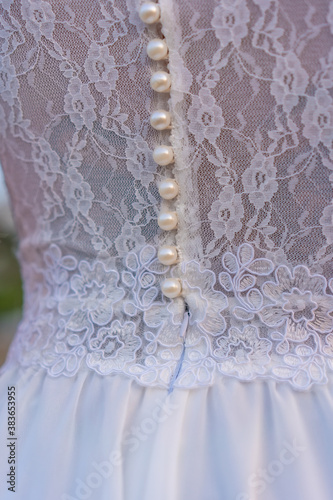 Lifestyle, detail of the seam texture of the bride's beautiful white dress. Caucasian brunette on her wedding day