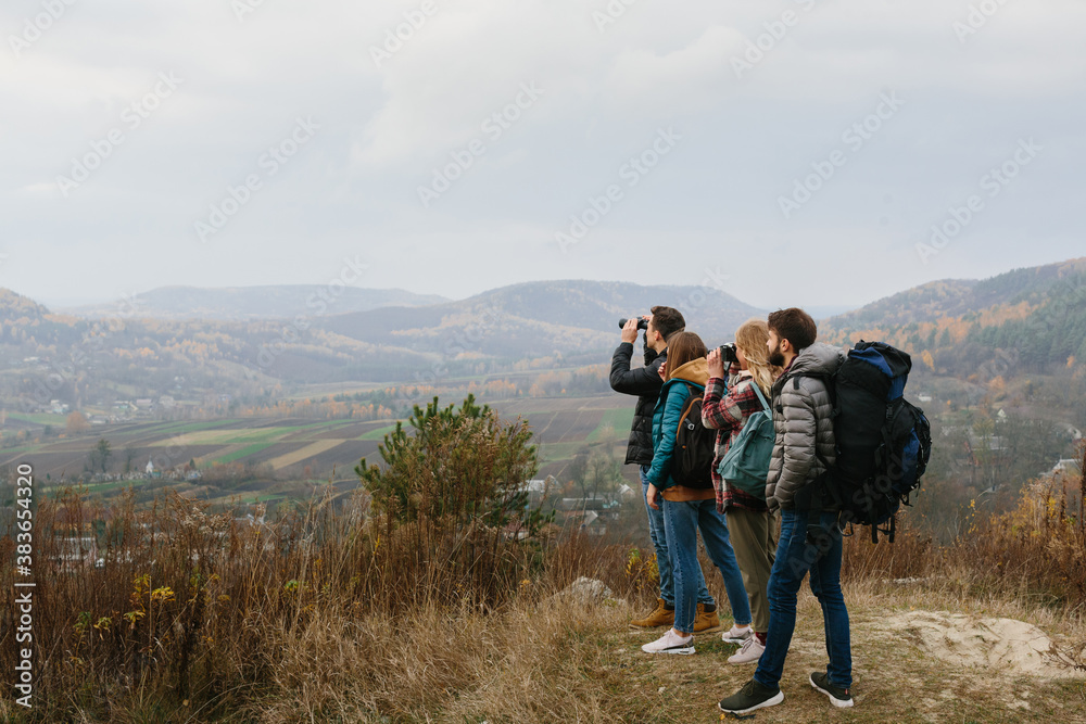 Friends are enjoying sunny autumn weather while hiking in the mountains