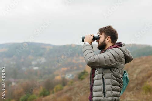young traveler man with binoculars