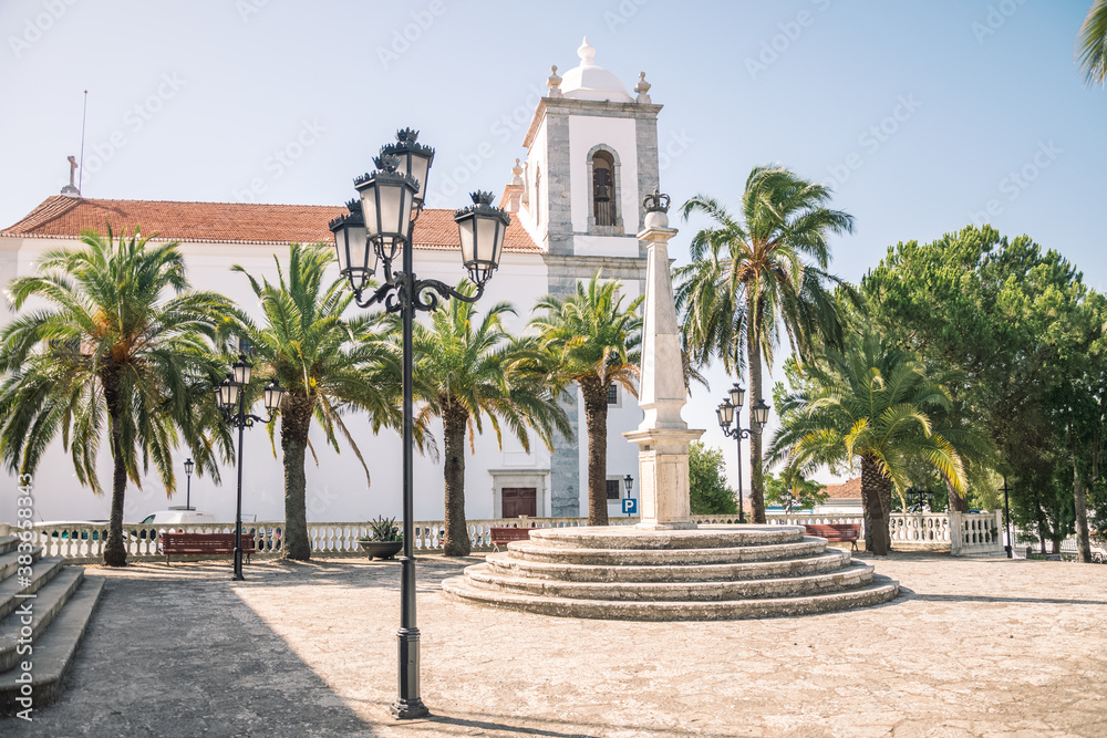 beautiful church built of stone. Church with a bell tower. and a small park with palm trees. Church in Portugal