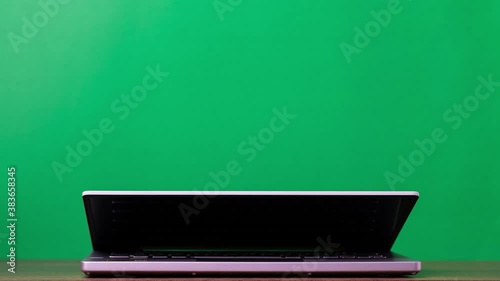 Working on laptop at home-office. 4k Stop motion opening and closing laptop computer on green background. Business concept work.